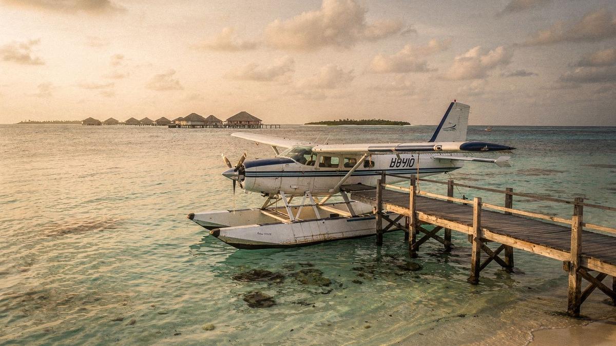 Seaplane moored at a Maldives lagoon jetty in the late afternoon