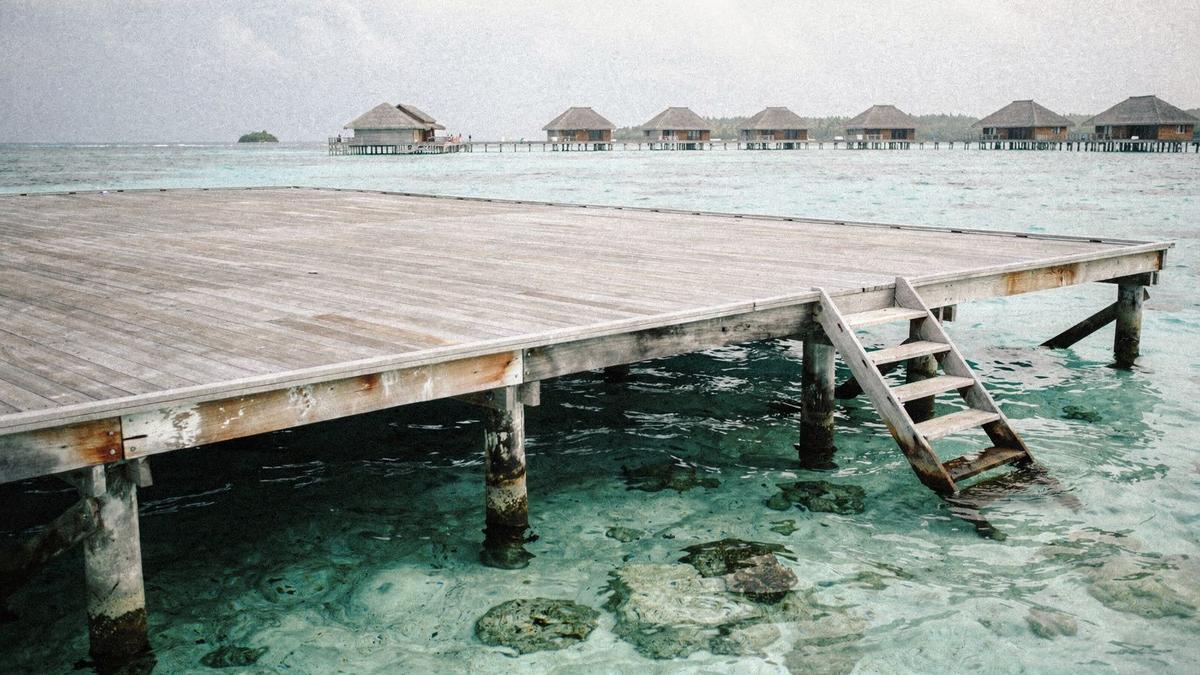 Overwater villa deck above clear turquoise water in Baa Atoll